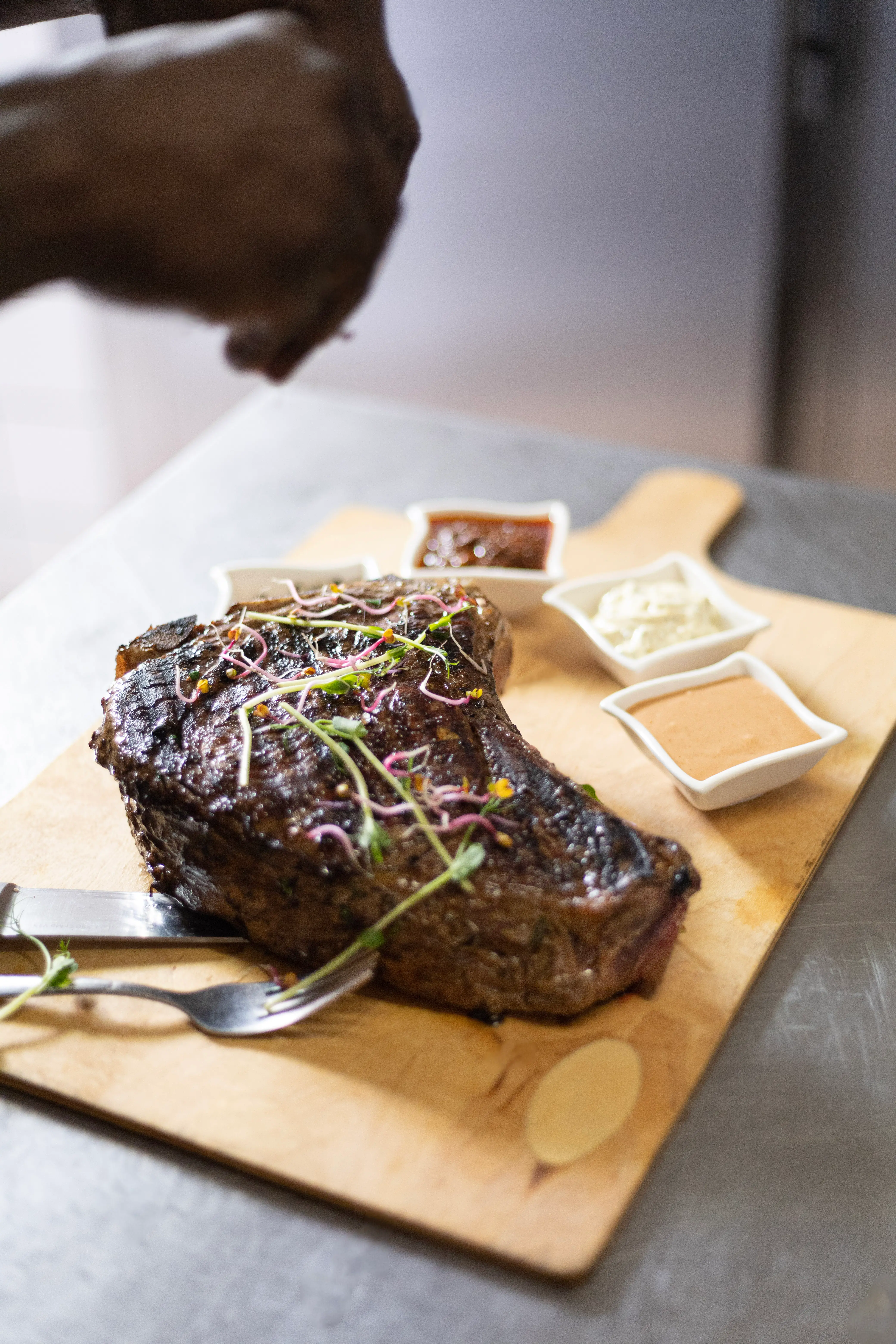 Côte de bœuf assaisonnée servie sur planche, sauce maison